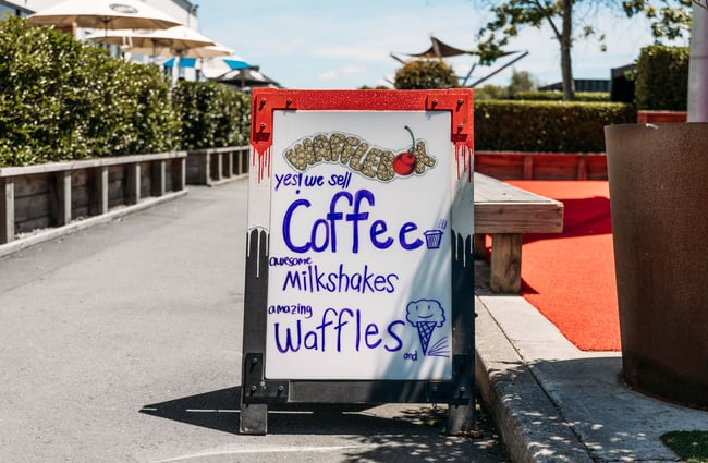 A 'coffee and milkshakes' sandwich board sign.