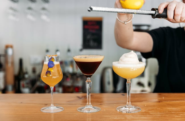 Three cocktails on a row on a counter.