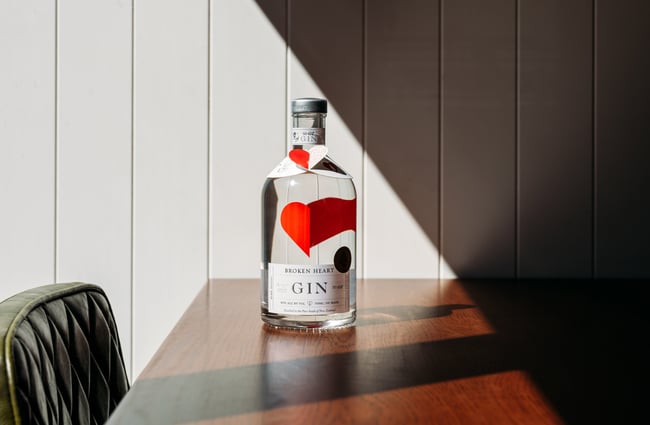 A bottle of gin sitting on a table in the sunshine.