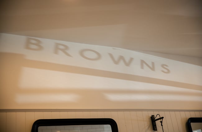 A 'Browns' sign reflected on a wall.