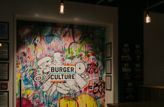 Graffiti on a wall with Burger Culture logo.