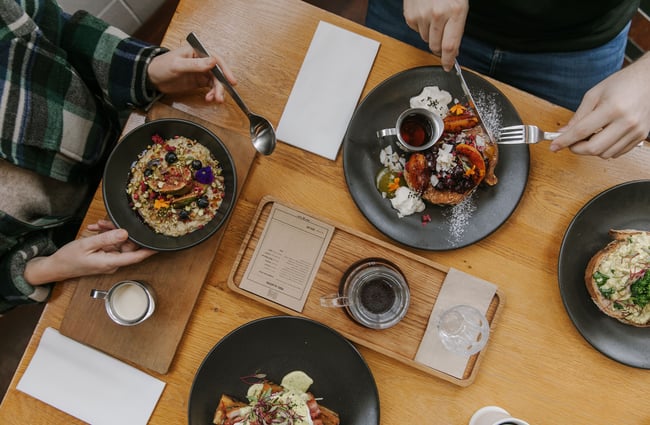 A flat lay of people sitting behind plates of brunch at a table at C4.