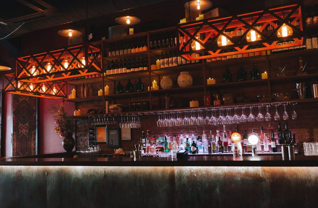 The bar at Candela Bar in Auckland with red lights creating a red and dark ambuance.