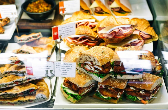 Close up of filled sandwiches and croissants in the café's cabinet.