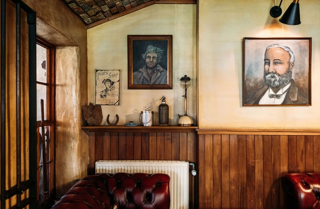 Framed paintings on the walls, above the timber dado, inside the Cardrona Hotel pub area.