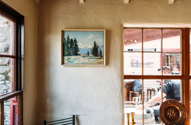 A framed landscape painting hung on a wall at Cardrona Hotel.