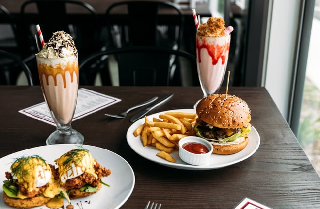 Burgers and thick shakes on a table.