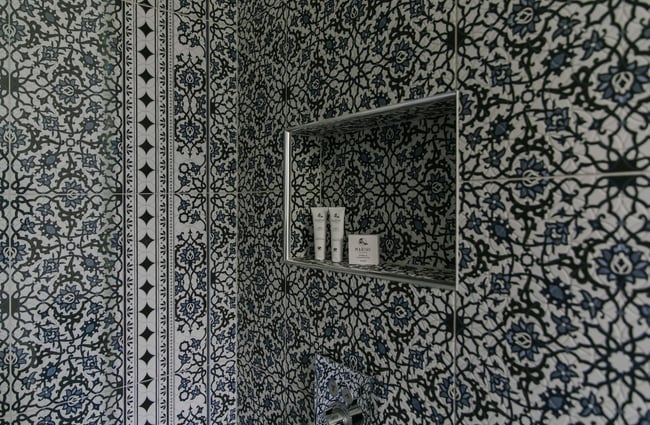 A blue and white tiled shower.