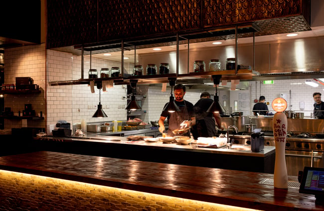 A chef working in the open kitchen at Cassia.