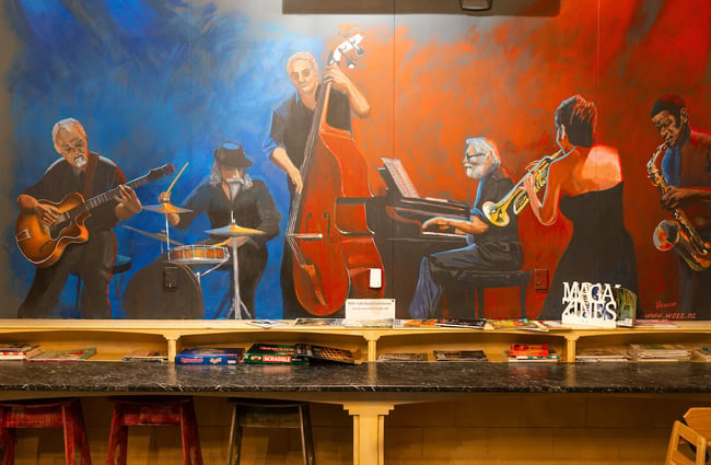A mural of musicians on the wall above the cafe's range of board games.