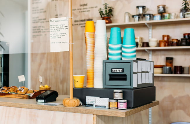 The counter with stacks of colourful takeaway coffee cups.