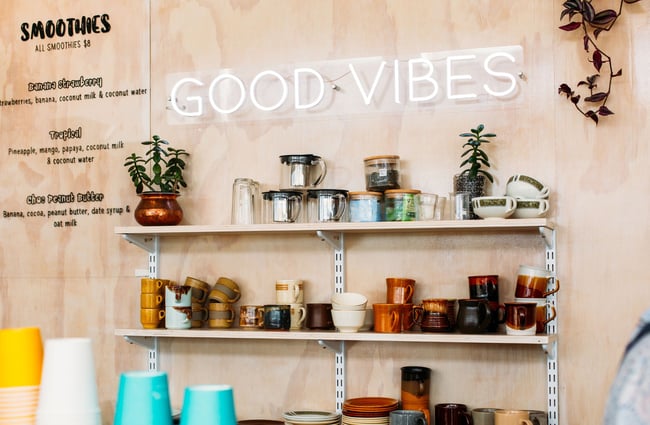 An LED light up sign that says Good Vibe on the wall.