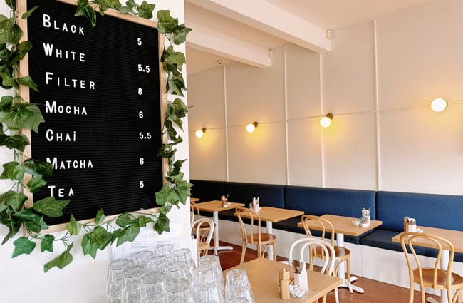 Letter board with coffee and prices on the wall at Comes & Goes café in Petone.