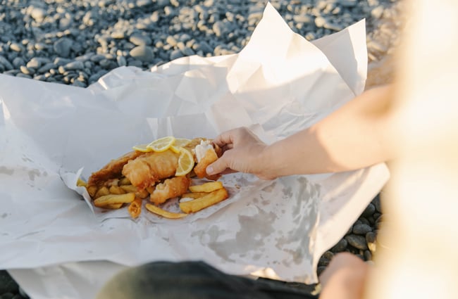 Takeaway fish and chips in paper wrapping.