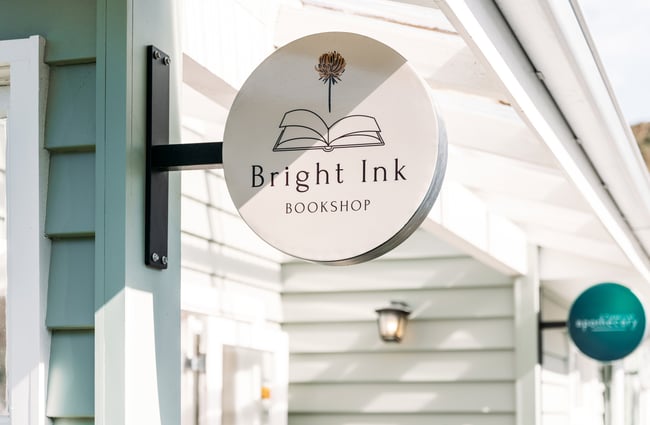A 'Bright Ink Bookshop' sign secured to the side of a building.