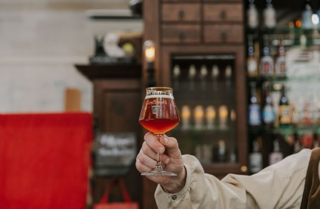 A person holding up a glass of Rose wine inside the Craftwork Brewery.