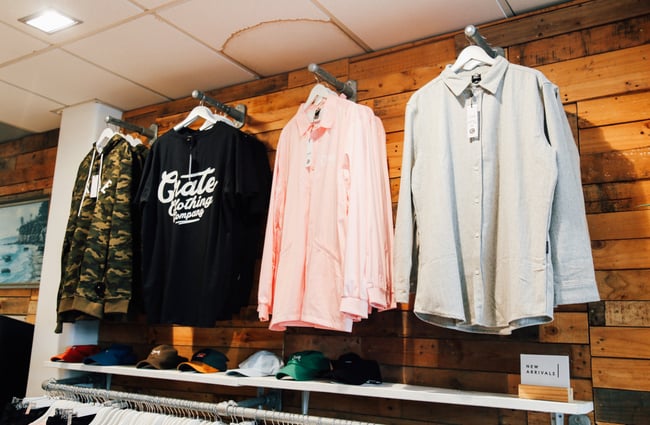 Shirts and t-shirts hanging up on a wall inside Crate clothing store Hamilton.