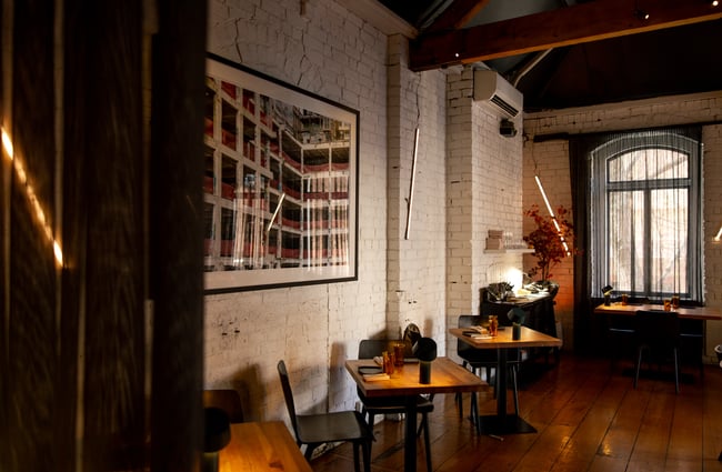 A white painted brick wall inside a dimly lit restaurant.