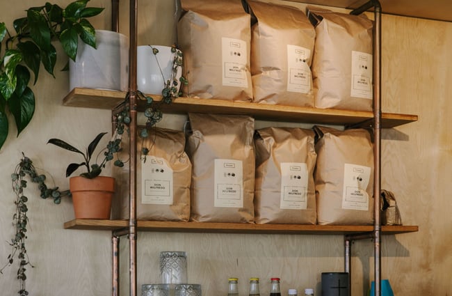 Big brown bags of coffee beans on shelves inside Curbside.