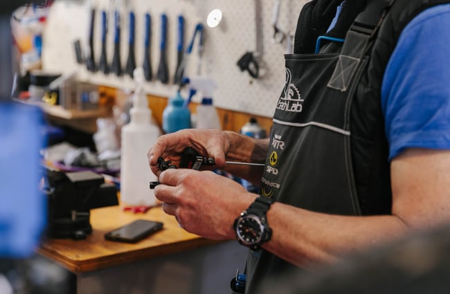 Close up of hands holding a bike part at Cycle Ventures in Waitaki.