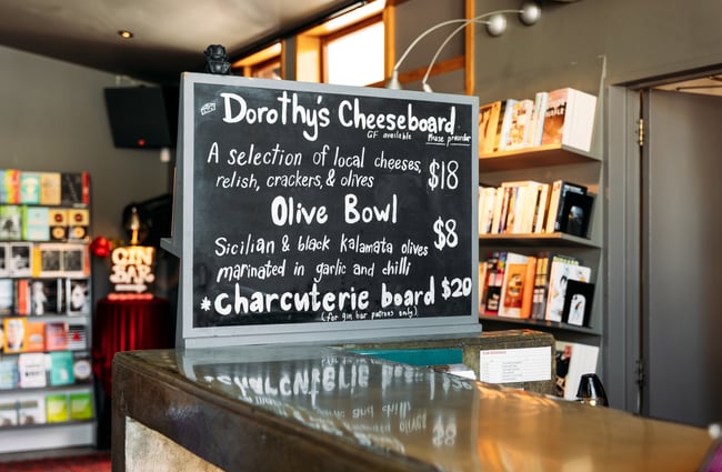 A blackboard sign promoting cheese boards.
