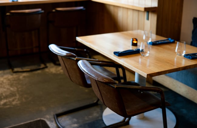 Detailing of the modern leather chairs and clean wooden tables at Earl