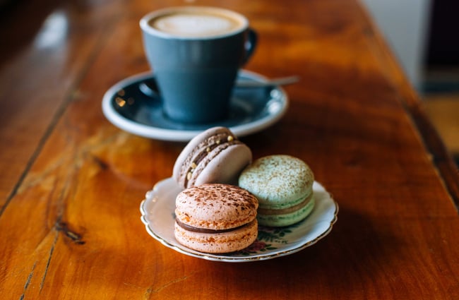 Macarons on a vintage and a coffee on a table at Emmalou Macaron & Coffee, New Plymouth.
