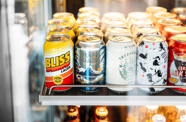 A close up of beer cans in a fridge.