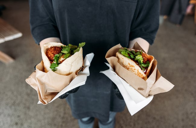 Two stuffed pitas in hands.