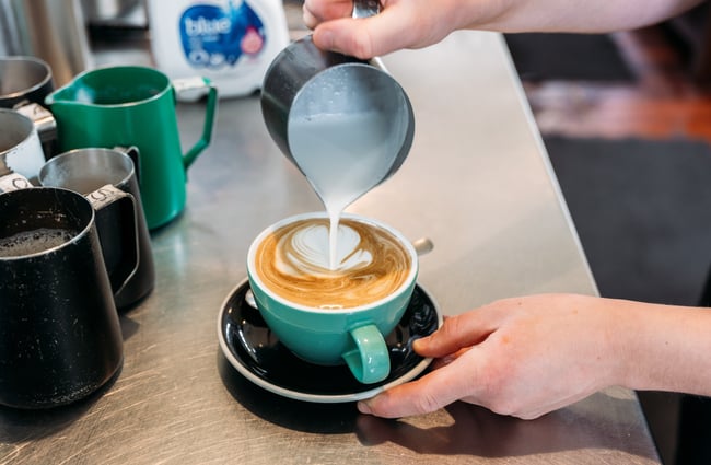 A flat white coffee being made.