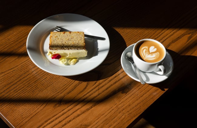 A slice of cake and a coffee on a table.