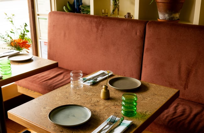 A green and yellow table setting inside Forest restaurant.