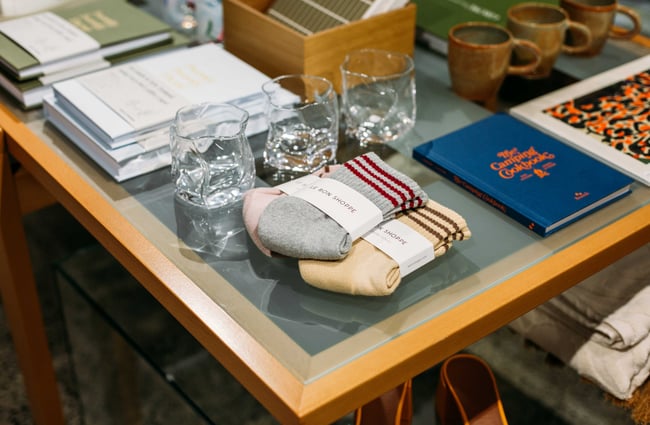 Close up of some socks on display next to some glasses on a table.
