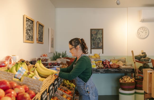 A woman looking at fruit and vegetables on display.