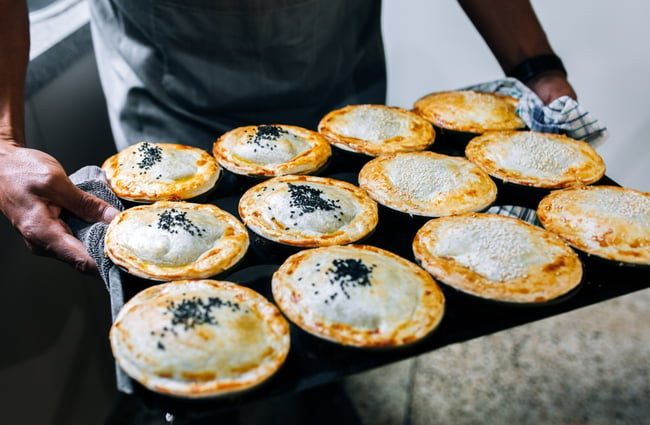 Baker holds tray of pies at Gather Foodhouse, Hamilton.