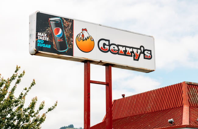 A Gerry's chicken sign outside the building on a grey day.