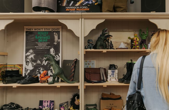A woman browsing Godzilla merchandise on shelves.