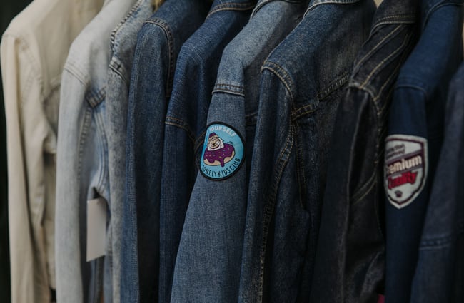A close up of the sleeves of denim jackets.