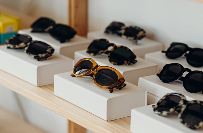 A close up of sunglasses on a shelf.