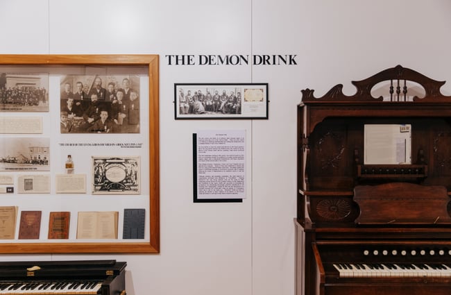 An exhibition of moonshine featuring a piano and signage.
