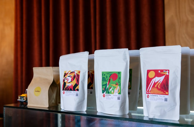 Colourful bags of Fuglen coffee on shelf at cafe
