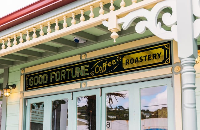 Close up of House of Good Fortune cafe sign on exterior of old villa building