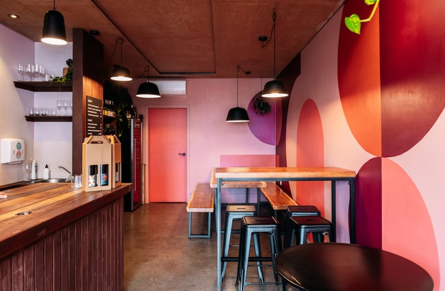 The pink and purple painted walls inside a bar.