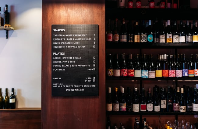 Bottles of wine on display next to a chalkboard menu.