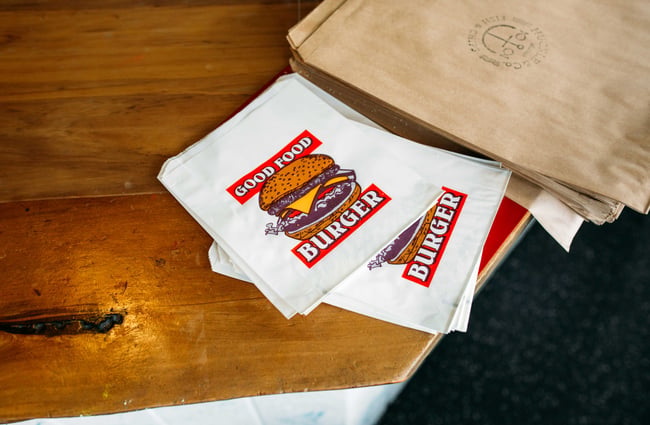 Close up of a paper bag with a burger printed on it.