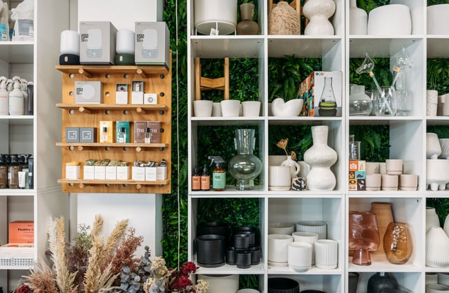 Vases and other homewares on display on white shelves.