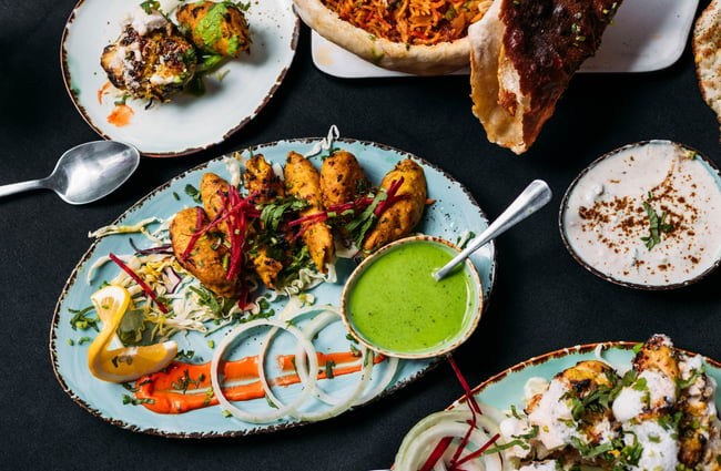 A close up of Indian starters on large plates.