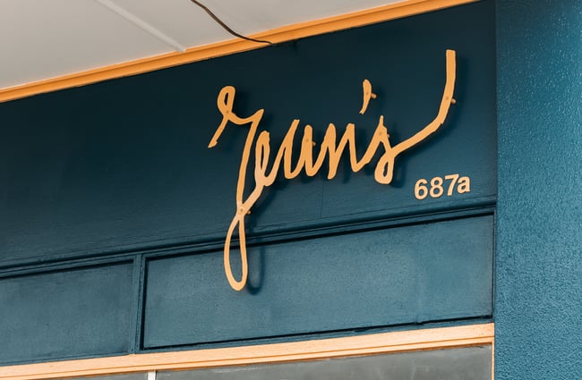 A close up of the 'Jeans' sign at the top of an exterior cafe wall.