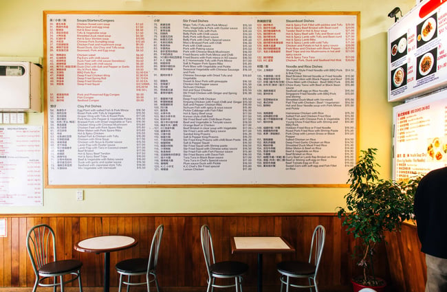 A large menu on a wall inside a Chinese restaurant.