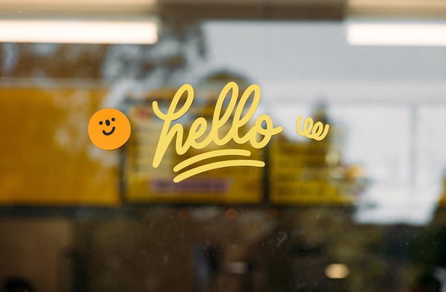 A sign that says 'hello' on a glass window.